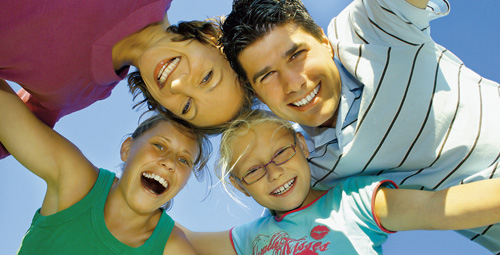 Smiling parents and children looking down at camera